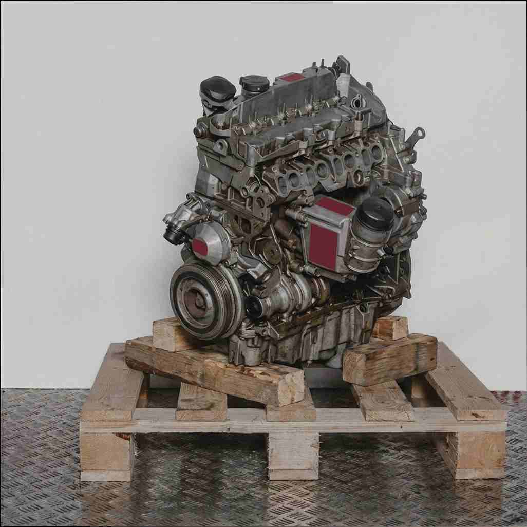 Moteur N47 C16 A gris sur palette en bois, fond blanc. Vue latérale du moteur.