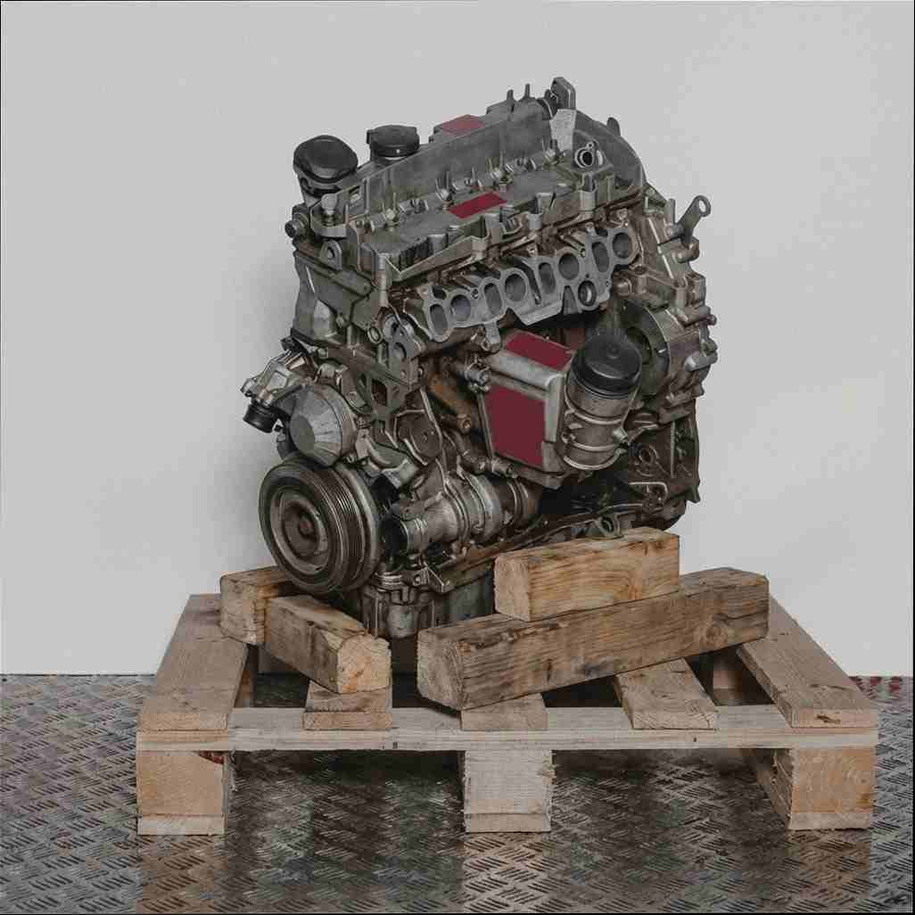 Moteur N47 D16 A détaillé sur palette en bois, fond blanc. L'image en niveaux de gris présente le moteur de côté, légèrement en biais.
